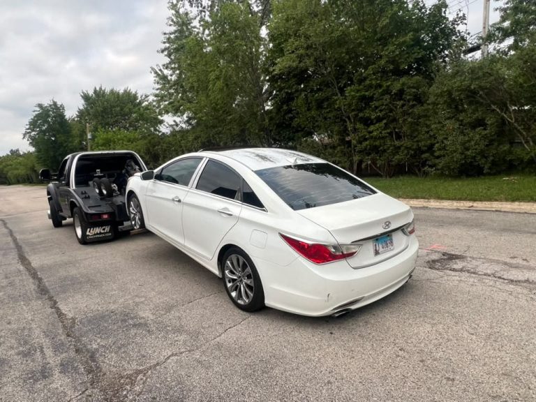 White sedan being towed by Blackhawks Towing in Chicago